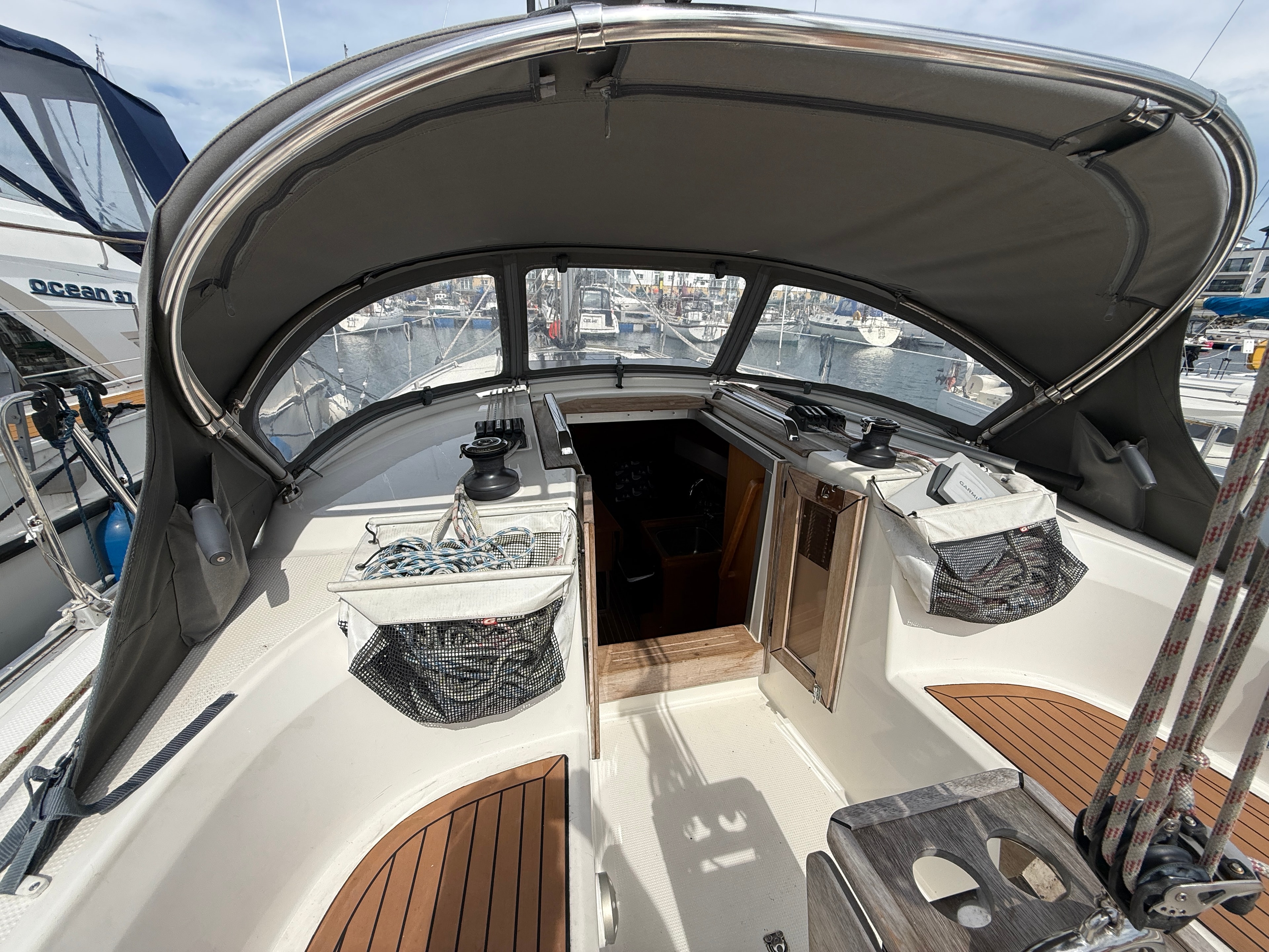 Cockpit interior under canopy — teak sole, companionway open