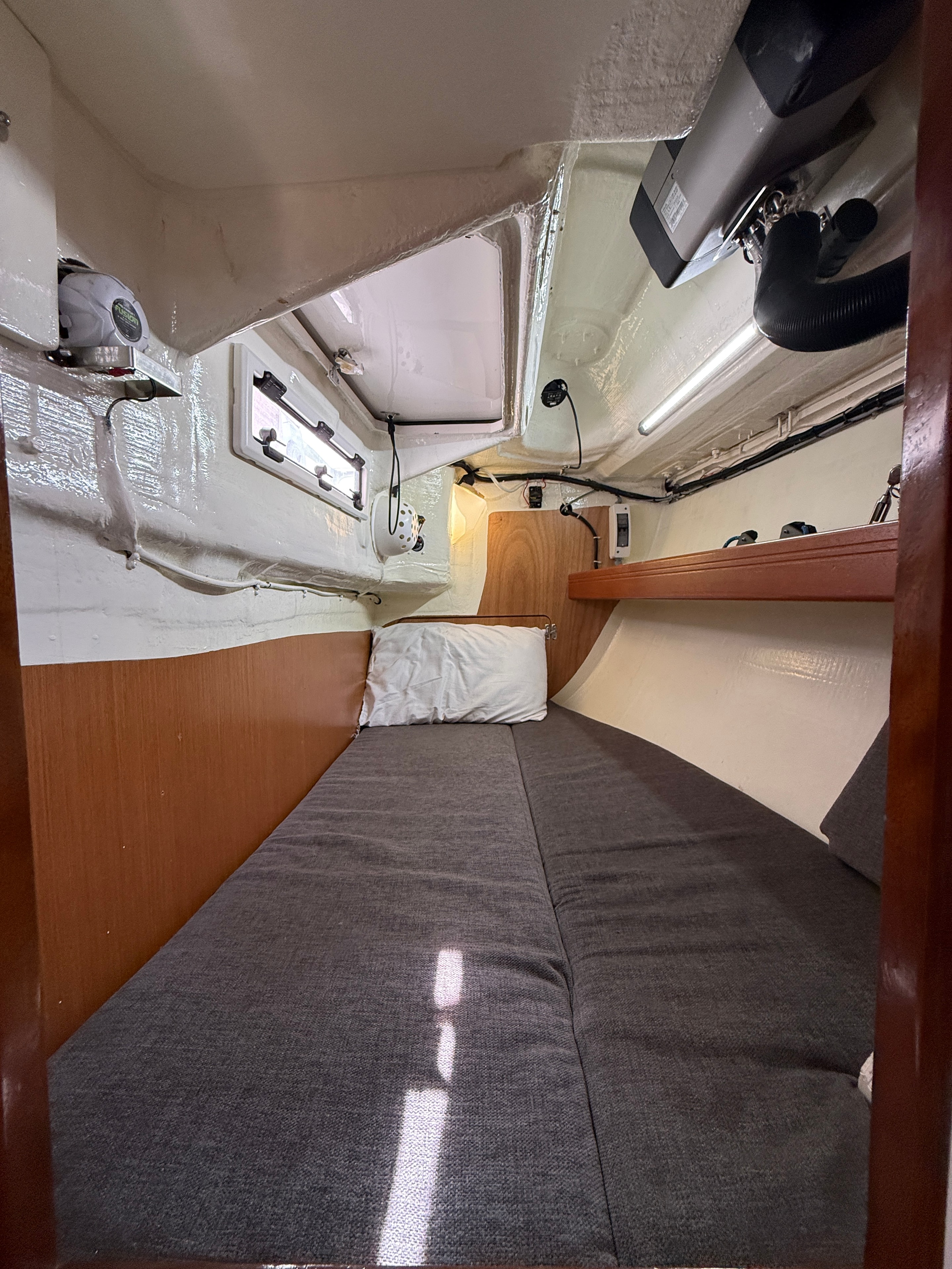 Aft cabin — grey upholstered berth, nav station, LED lighting