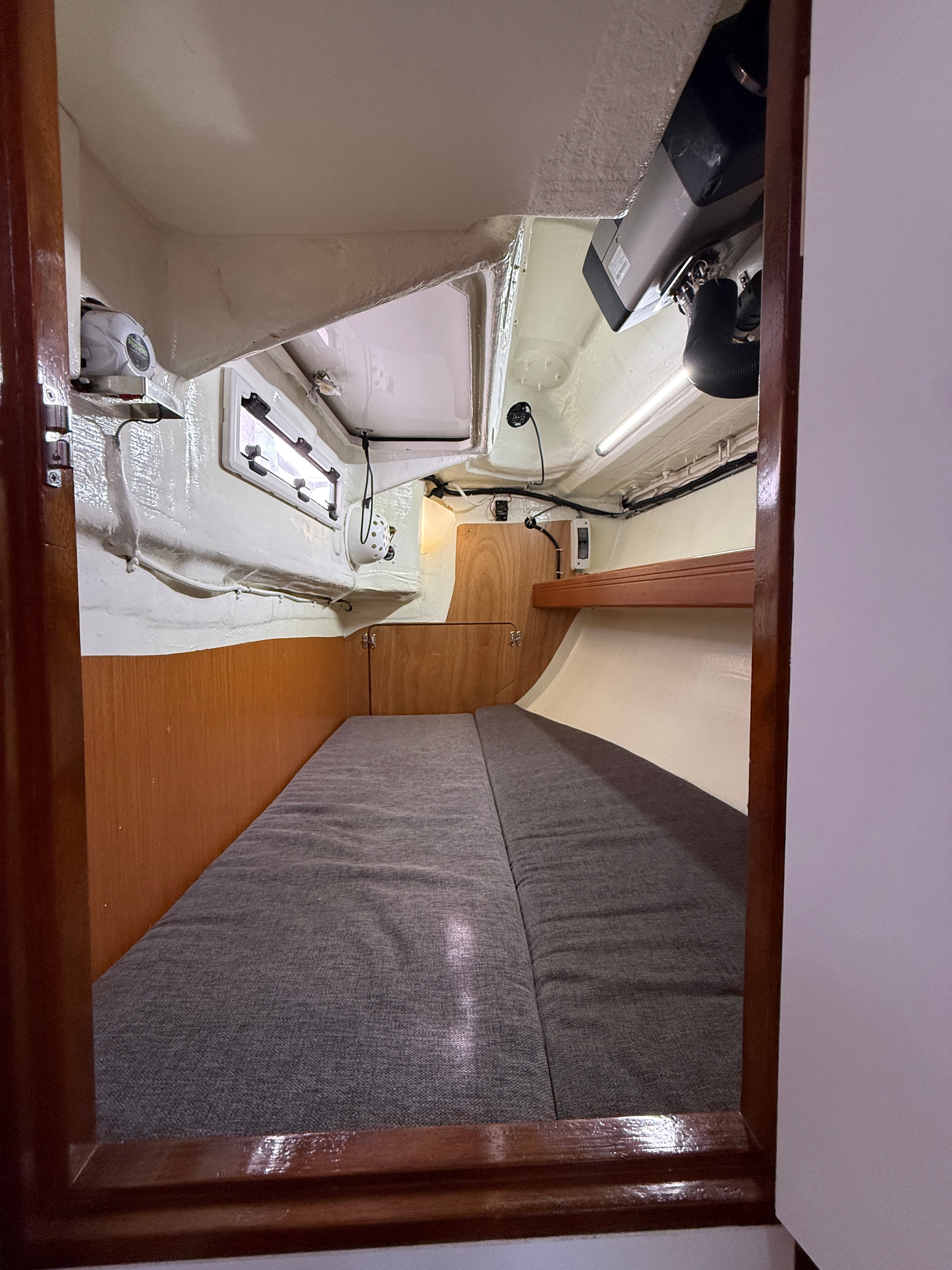 Aft cabin — grey berth, nav station instruments, LED lighting