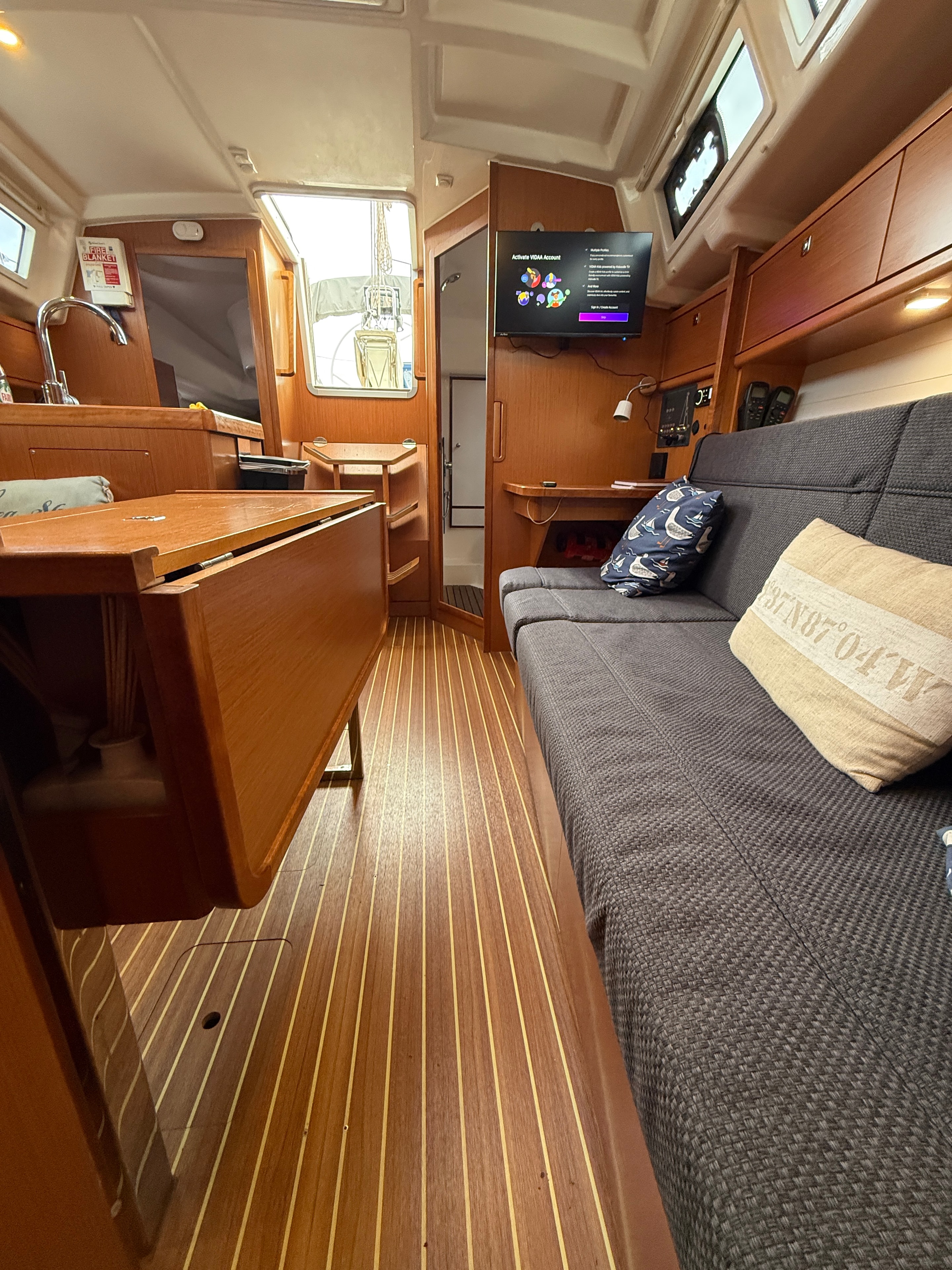 Teddy — saloon looking forward, Avtex 24" TV, nav station and Oceanline teak flooring